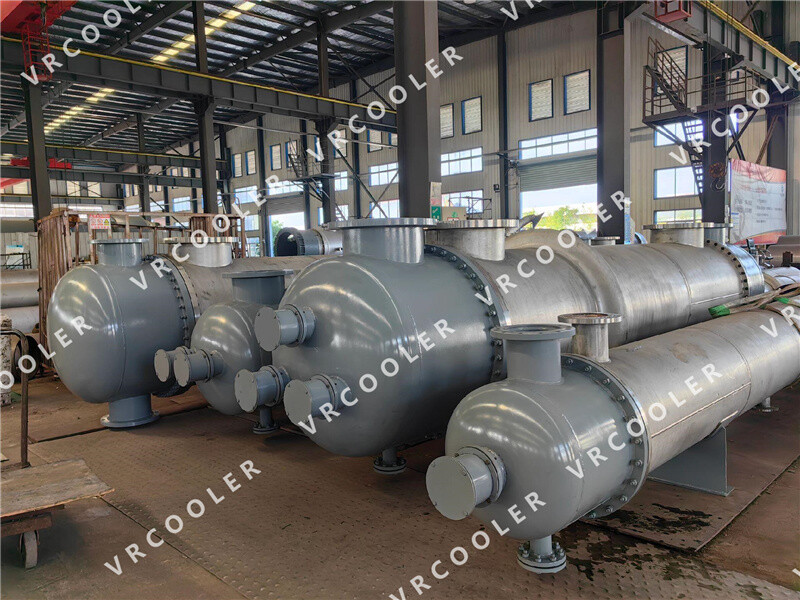 What are the common tube and shell materials for shell-and-tube heat exchangers used in chemical processing?