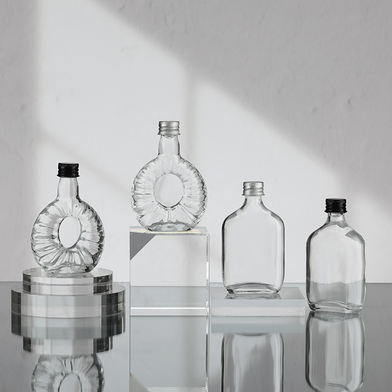 Mini botella de licor de vidrio con tapa de aluminio.