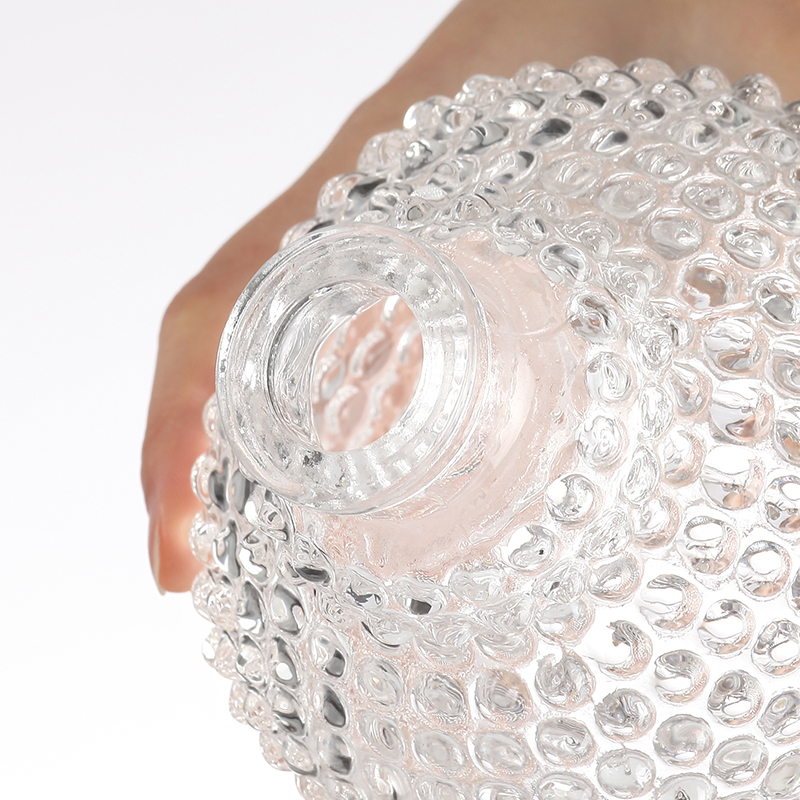 Botella de cristal transparente con forma de cabeza de Buda.