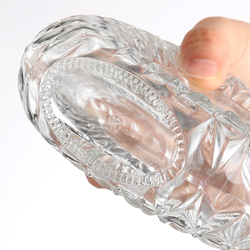 Botella de vidrio redonda con patrón intrincado.