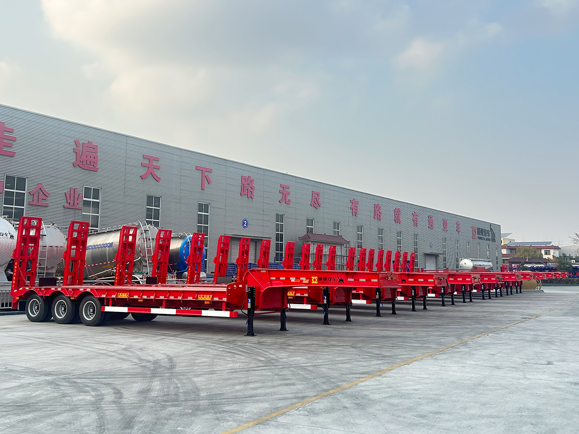 Una gran cantidad de semirremolques de cama baja listos para ser enviados al extranjero.