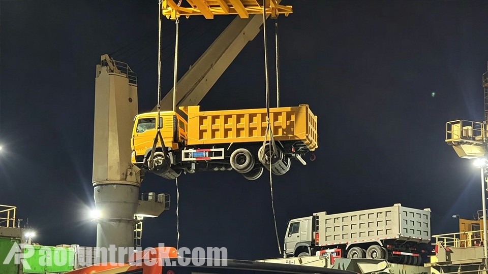 Caminhões basculantes SINOTRUK HOWO TX 6x4 bicolores atracados no porto para embarque marítimo à República do Congo
